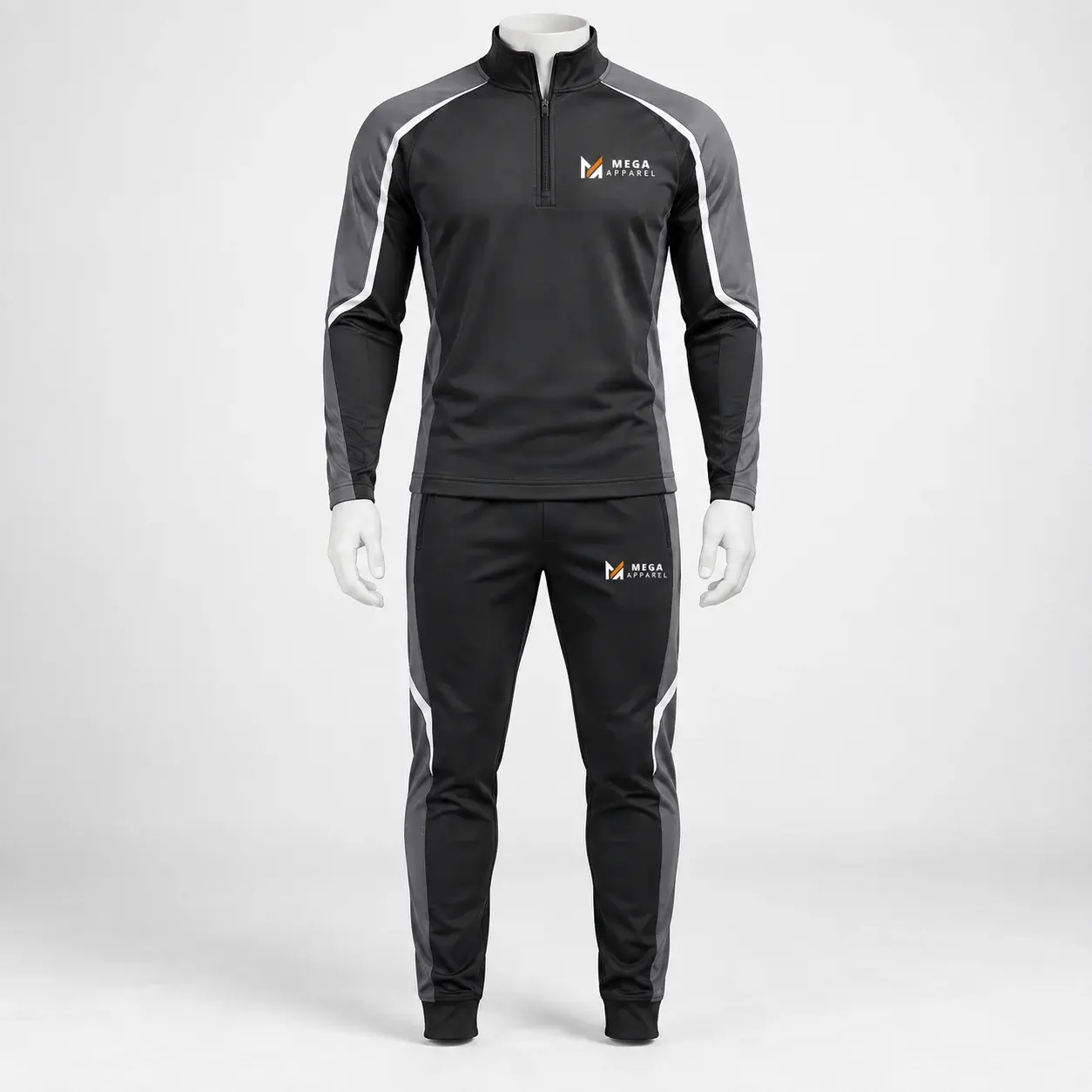 Black and charcoal half-zip tracksuit set with white piping, fitted performance top, matching tapered pants, and Mega Apparel logos on the chest and pants.